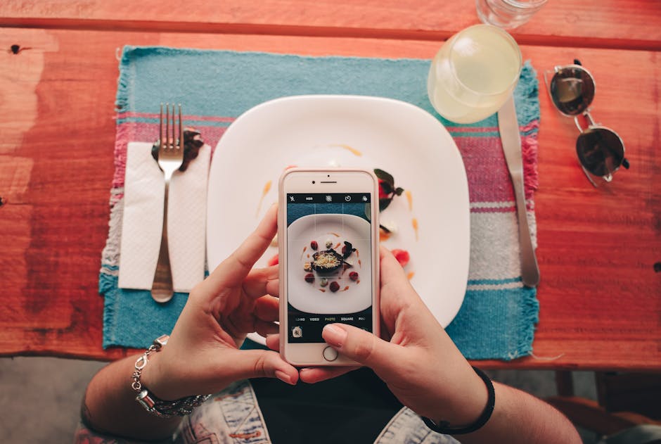 Une cliente prend en photo un dessert dans un restaurant avec son smartphone