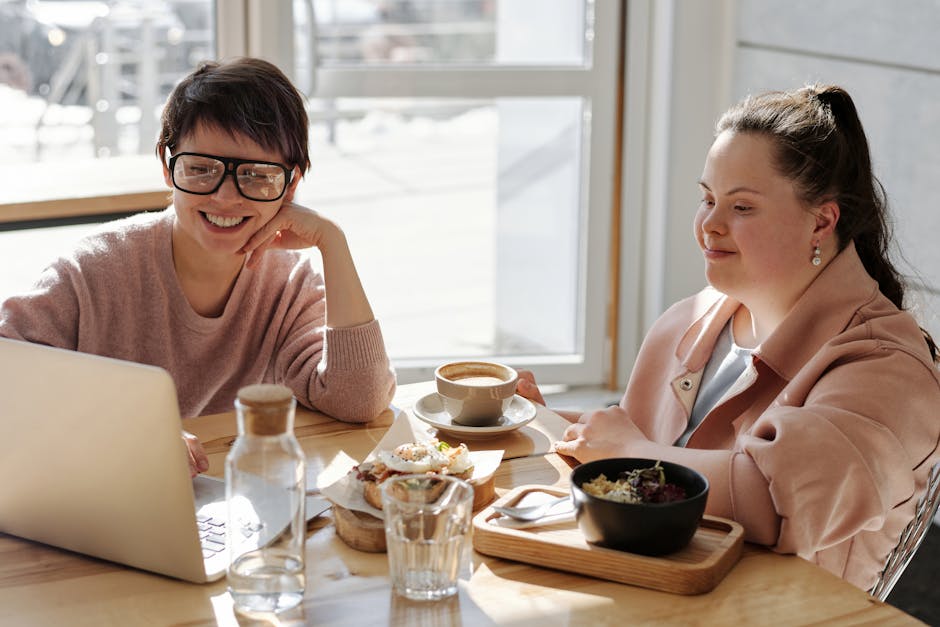 Two smiling women having coffee in a modern, bright setting