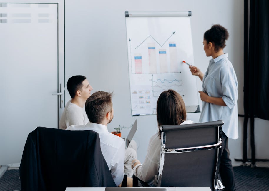 Équipe professionnelle en réunion analysant des graphiques sur tableau