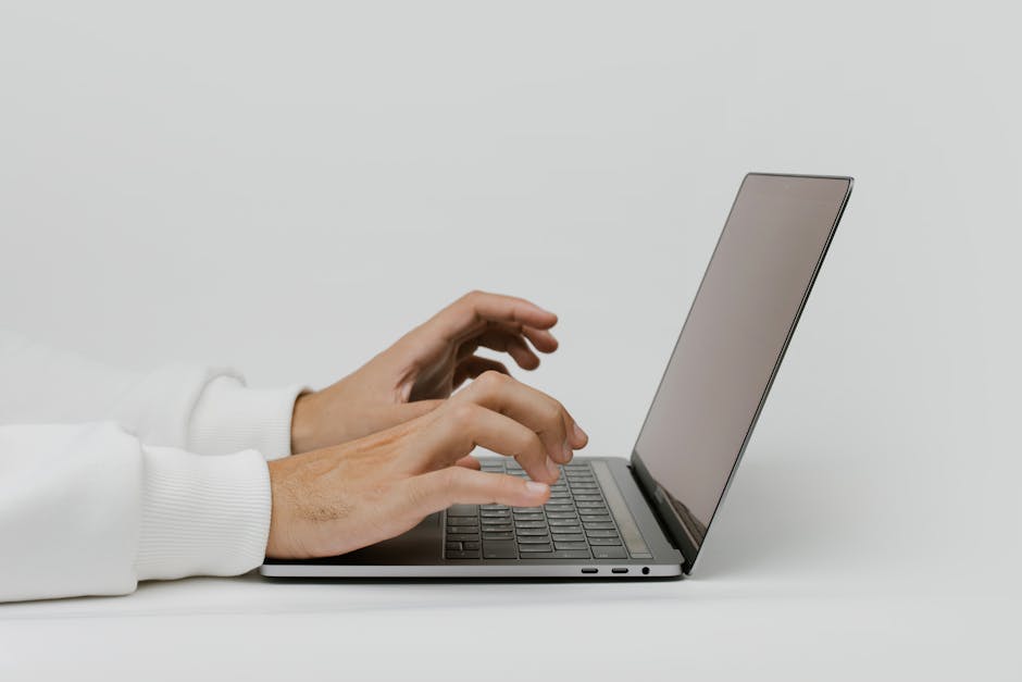 Gros-plan sur des mains tapant sur un ordinateur portable avec un espace de texte important. Idéal pour les thèmes de travail et de technologie.