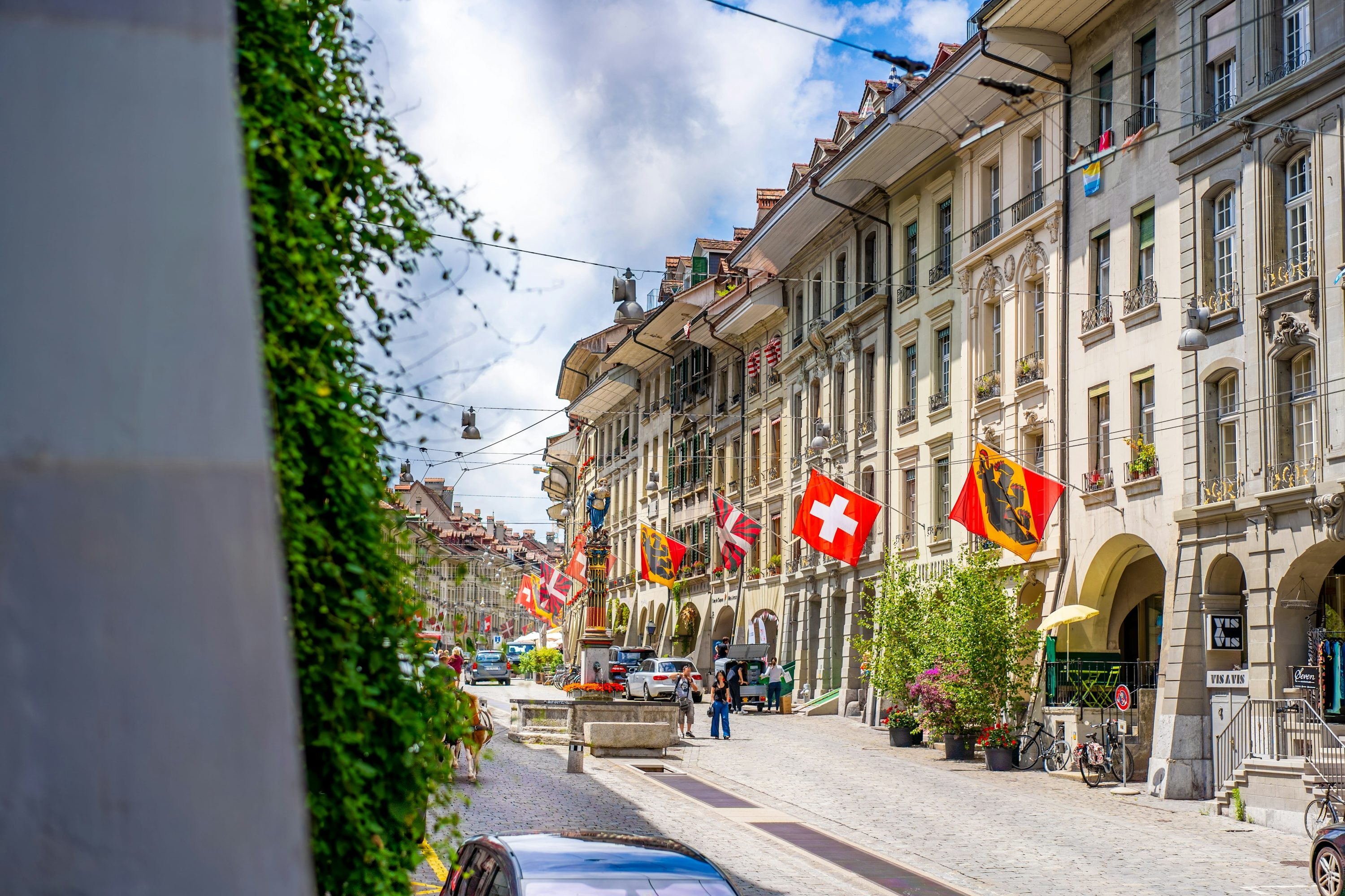 Personnes marchant dans une rue de ville près de bâtiments pendant la journée, évoquant des voyageurs en exploration urbaine
