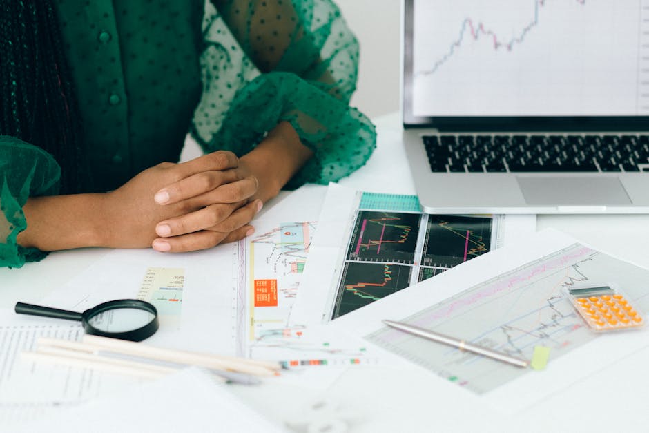 Personne analysant des graphiques financiers à un bureau, illustrant une activité commerciale