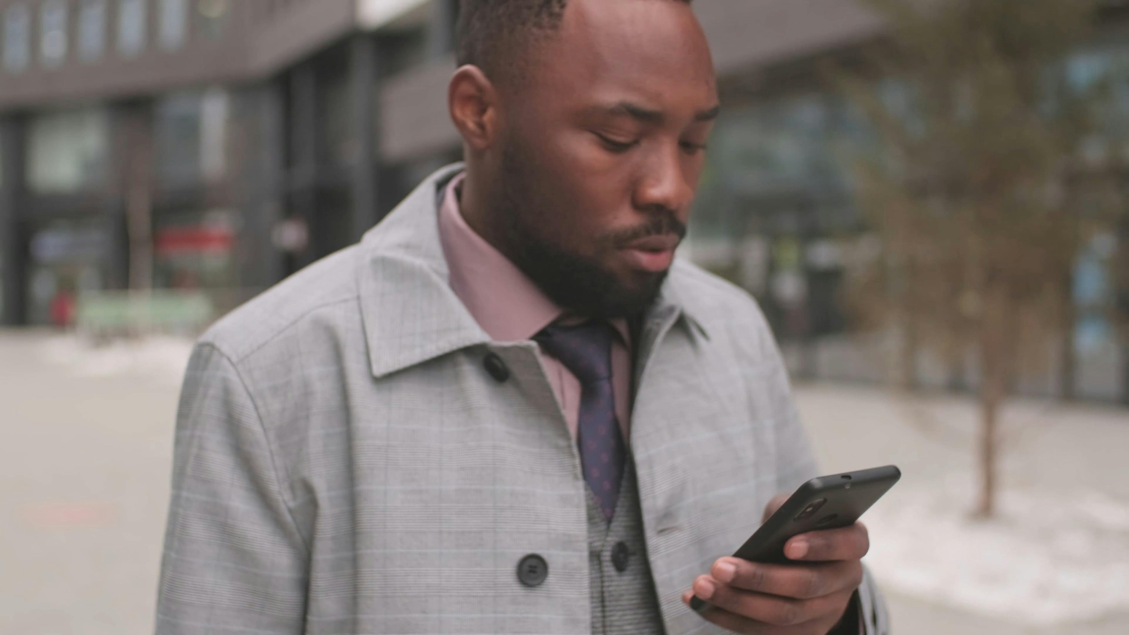 Personne en milieu urbain tenant un smartphone, évoquant communication digitale, connexion et diffusion virale d'une campagne de buzz marketing
