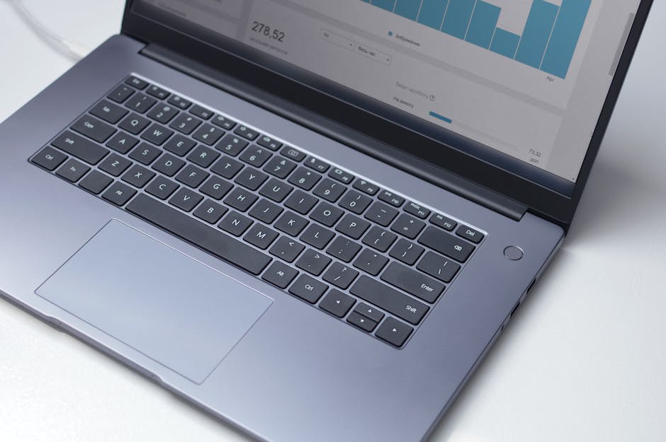 Ordinateur portable moderne vu de dessus avec un programme d'analyse ouvert sur l'écran, posé sur une table blanche