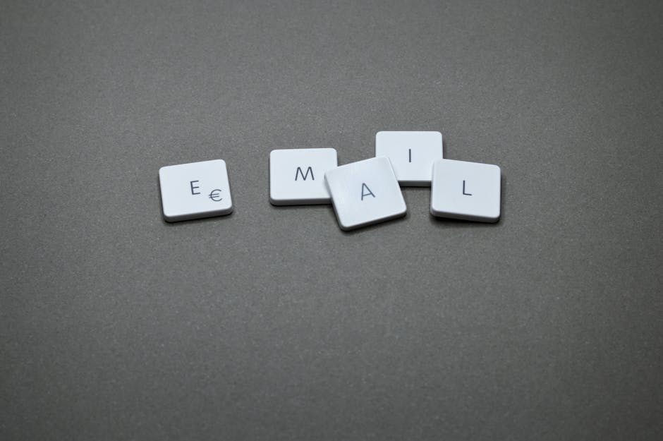 Gros plan du mot 'email' formé avec des lettres en bois sur une surface grise