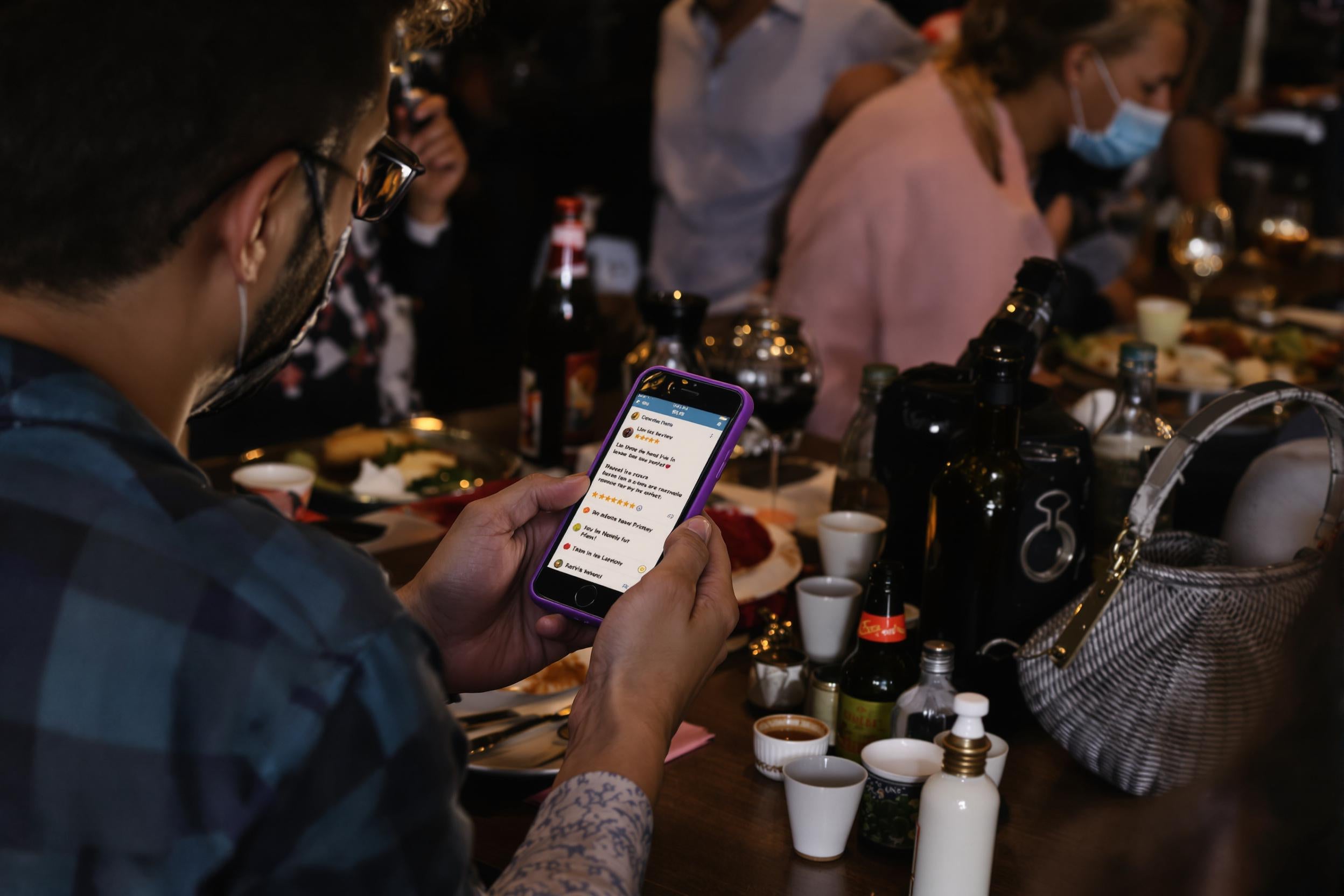 Des clients consultent des avis restaurant sur un téléphone