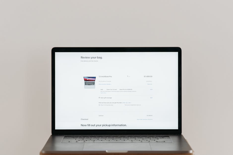 Computadora portátil minimalista que muestra una página de pago en línea sobre un fondo blanco, ideal para un contexto tecnológico.