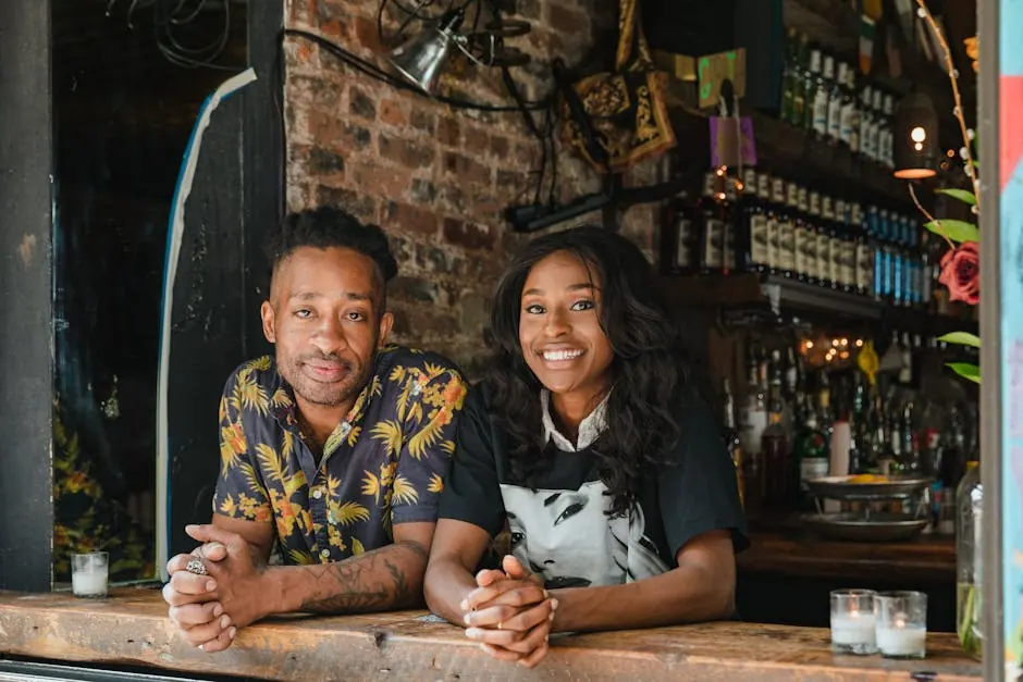 Un couple souriant en tenue décontractée au comptoir d'un café chaleureux, entouré d'une décoration conviviale.