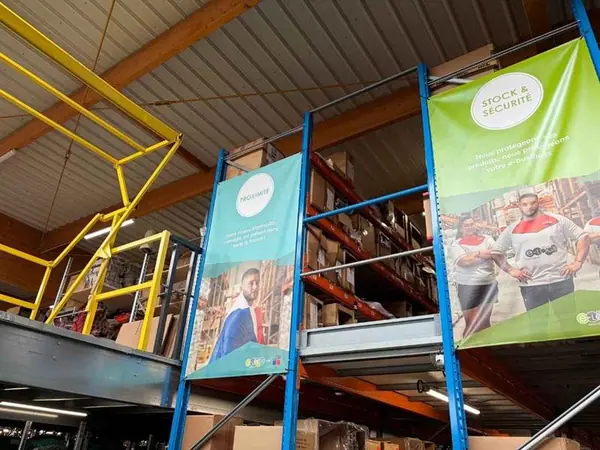 Entrepôt logistique d'Etxe Logistika, rayonnages de cartons et bannières de l'entreprise