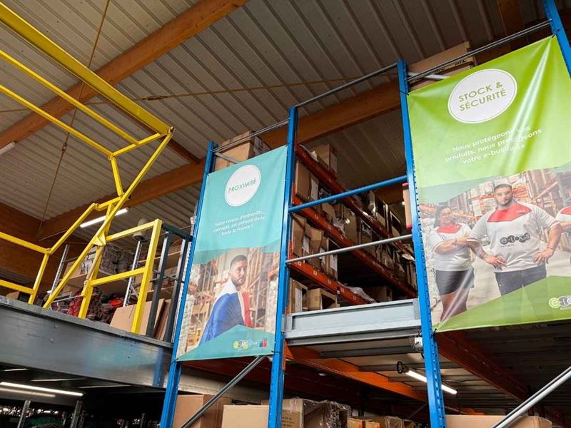 Almacén logístico de Etxe Logistika, estanterías de cajas y pancartas de la empresa